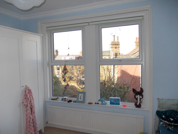 blackout roller blinds discreetly installed at a pair of windows
