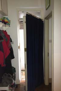 Portiere rod and interlined curtain fitted to Front Door in North London - the door is half open