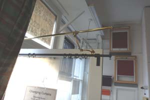 Portiere rods of different types on display on shop door in North London - door fully open