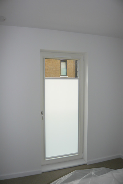 White framed nano blind, top down bottom up for door, blind covering the bottom three quarters of the glass