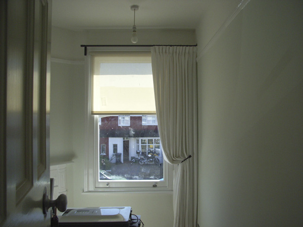 Single curtains can work well on asymetric windows - here the pole uses a recess bracket to attach to the side wall on one side a simple roller blind completes the picture 
