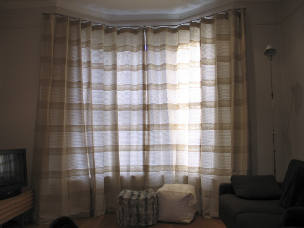 Linen curtains on a 25mm polished steel bay window pole from The Bradley Collection