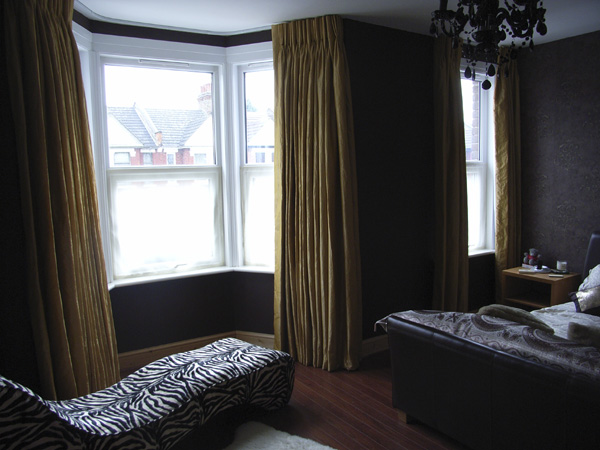 Faux silk curtains with a corded white steel curtain track fitted to ceiling