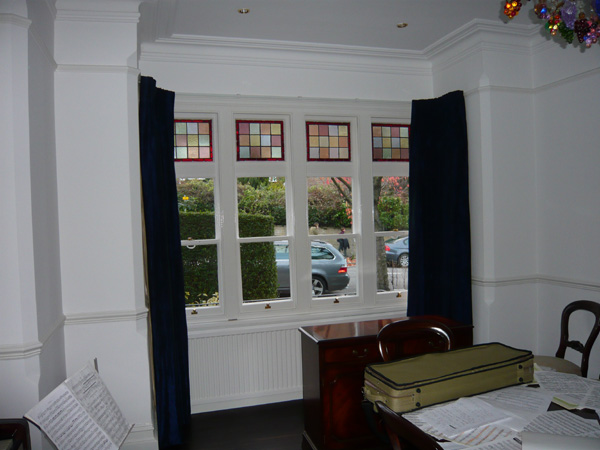 Faux silk curtains, interlined and pinch pleated, on a corded steel bay window track fitted to the top edge of the window architrave