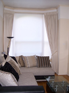 Goblet pleat curtains in cream damask fitted on covered fascia with plain white blinds Archway