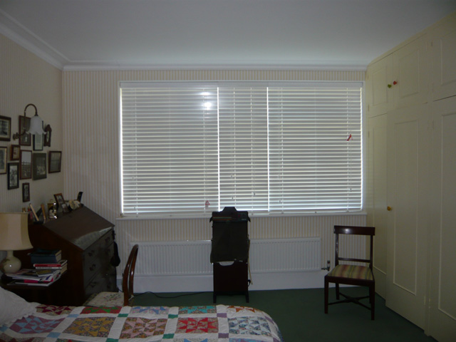 Three white 50mm slatted wood blinds - fully closed