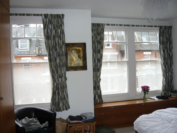 Curtains open, maximum light with tiebacks, no room to go further back in recess, single curtain for smaller window due to wardrobes on left hand side, shorter curtains to accomodate built in furnishings in room 