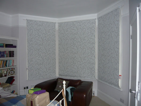 Blackout roller blinds lowered all the way in this bay window