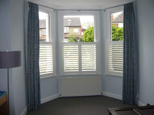Bay window curtain pole, a pair of curtains and cafe height shutters