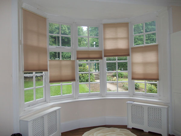 Bottom Up Top Down duette blinds installed in bay window for privacy and insulation, showing how versatile they are
