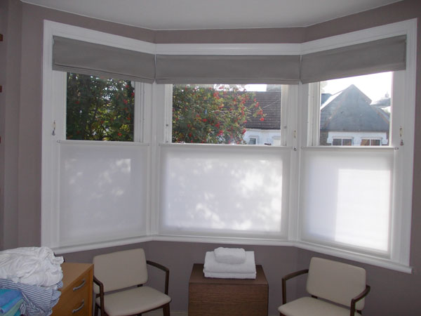 close up of bay window showing roman blinds with privacy panels