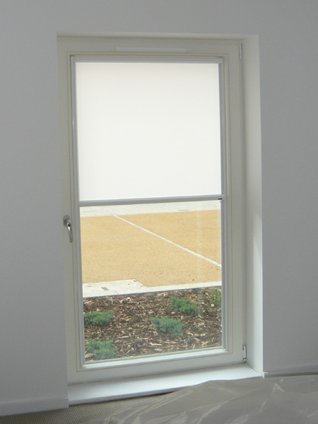 white luxaflex nano blind fitted to glass door - fabric now covering top half of glass