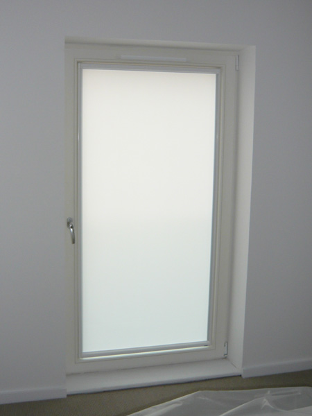 white luxaflex nano blind fitted to glass door - fabric covering the whole glass