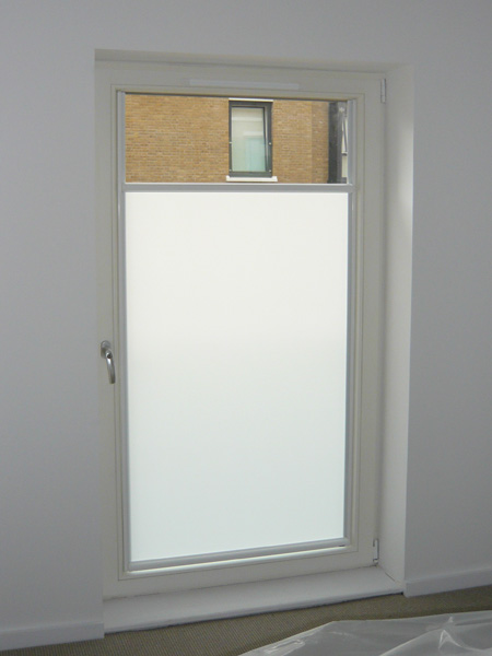 white luxaflex nano blind fitted to glass door - top cassette now lowered for use as a bottom up blind for privacy with light