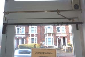 Portiere rods of different types on display on shop door in North London - door closed