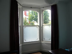 Artificial silk curtains on bay window pole Tufnell Park