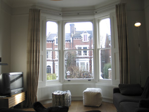 Linen curtains on a 25mm polished steel bay window pole from The Bradley Collection Highgate