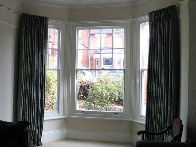 French cloque work in silk, interlined and pinch pleated curtains, corded steel bay window track fixed to the top edge of the window architrave 