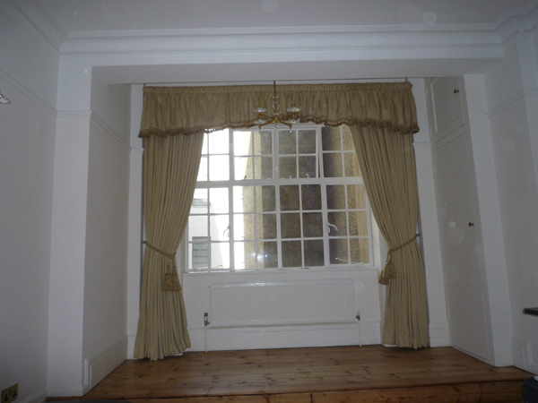 Gold damask curtains with gathered shaped pelmet with braid