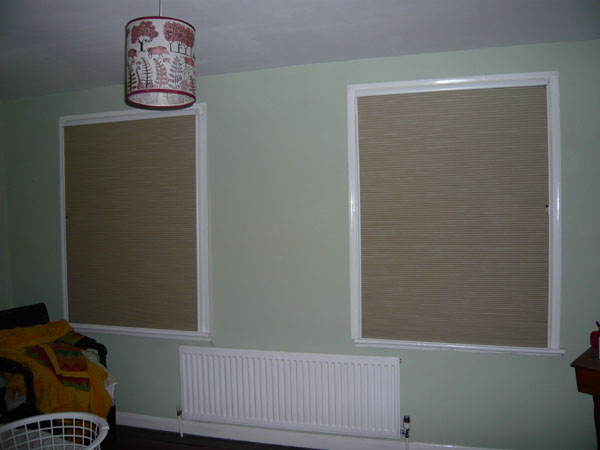 a pair of blackout duette blinds fully lowered inside side channels