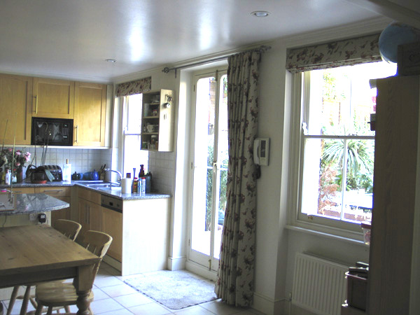 A combination of Roman Blinds at the windows with a single asymetric curtain on a pole at the french doors.