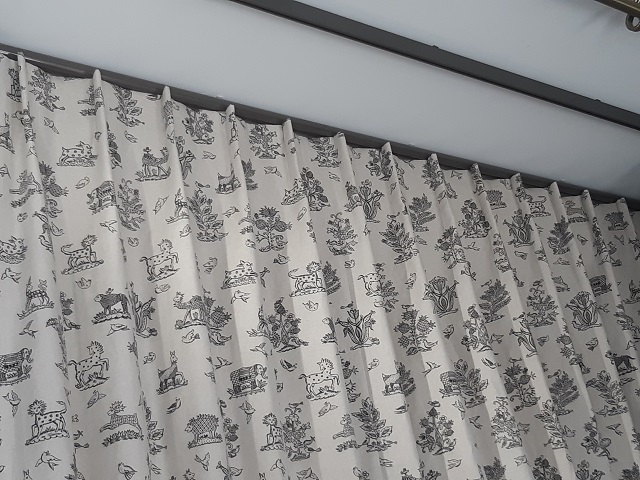 Cartridge Pleat curtain hanging below a Bradley Collection glider pole open - Changing Curtains Shop Display