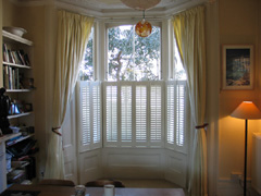 cafe height privacy shutters with linen curtains Islington