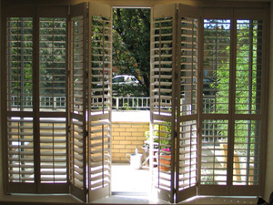 Wooden shutters with 89mm louvres in lime white on a tracking system installed in Central London