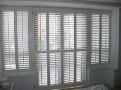 shutters in silk white wood with 63mm louvres are the only window treatment throughout this modern North London apartment Crouch End