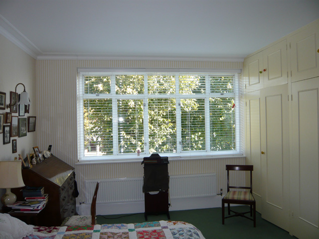 Three white 50mm slatted wood blinds - open